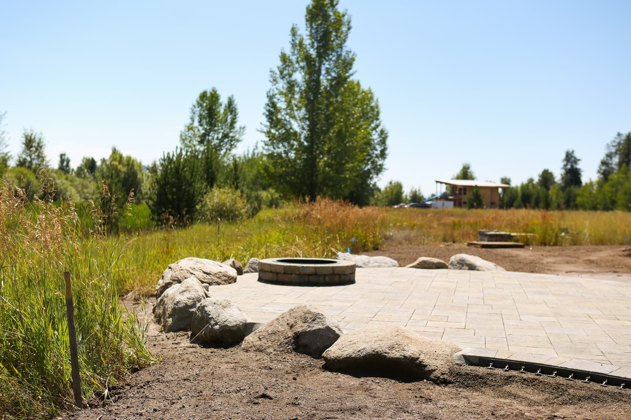 Paver patio, native grasses, boulders, and fire feature at a Franz Witte McCall landscape project