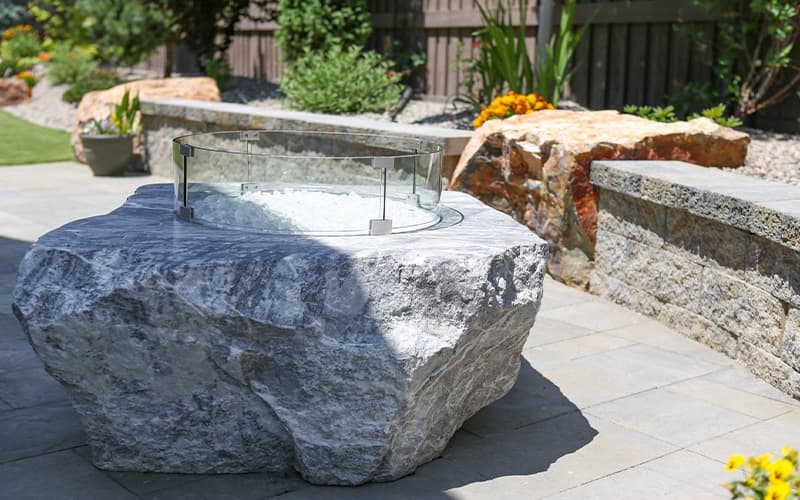A custom fire feature carved into a large natural stone