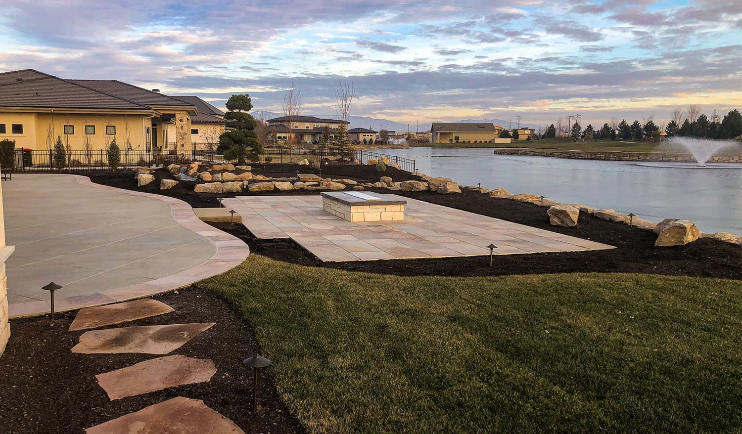 Completed patio, fire feature, planting, and lakeside landscape at the Meridian residence
