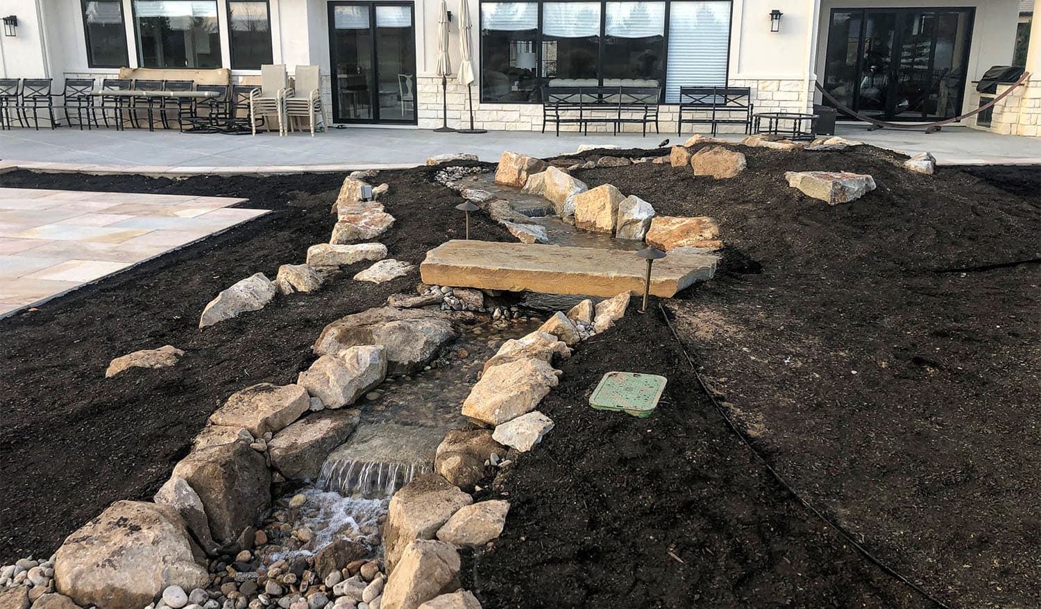 Stone-lined residential water feature under construction